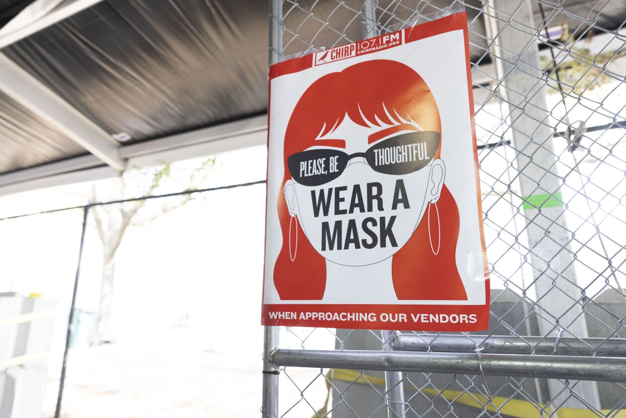 A sign asks people to wear a mask when shopping at a fair on Day 1 of the Pitchfork Music Festival.